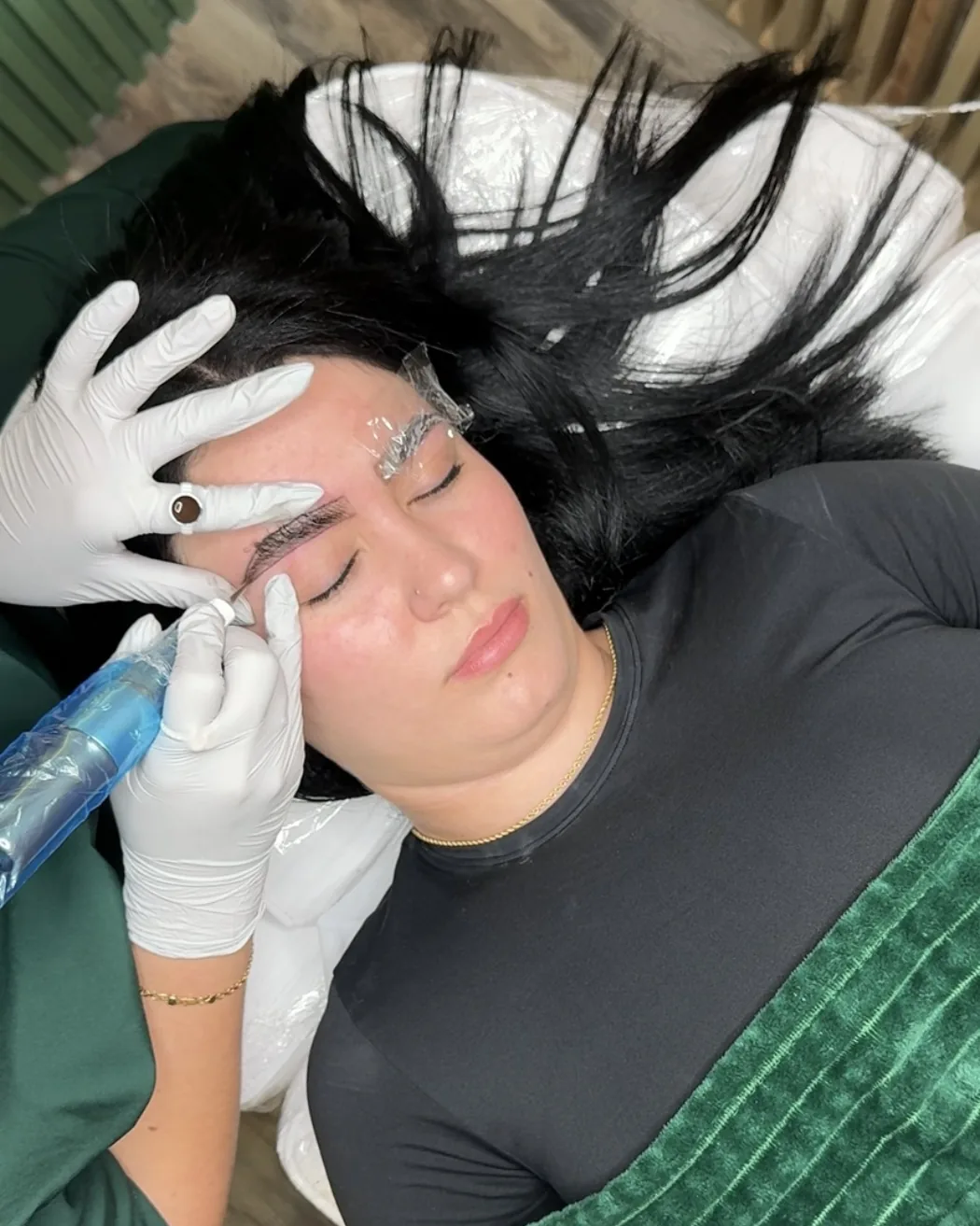 Permanent makeup artist shaping a client's brow at Mile C Beauty in Rockaway, NJ